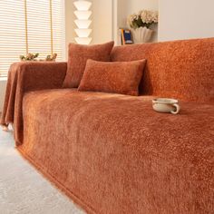 a living room with a couch covered in blankets and pillows