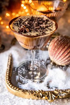 two desserts are sitting on a tray in the snow, one is topped with chocolate