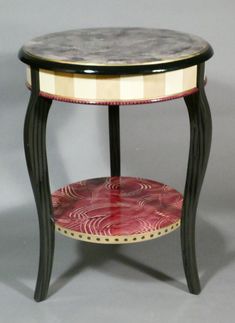 a small table with a red and black design on it's side shelf,