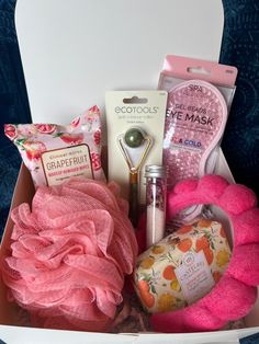 the contents of a pink gift box are neatly packed and ready for someone to put them in