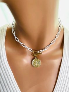 "This is a St. Benedict choker necklace for women.  Ancient coin pendant is 14kt gold filled, features the Benedict cross on both sides and measures 21mm.  Comes on a white enamel paperclip chain, links measure 12x6,with a toggle clasp in front.  Very trendy this two-tone necklace is even more lovely in person.  Comes in a cute gift box!  Model is wearing a 15\" length. CHOSE YOUR LENGTH. Do you have the option of cheese black chain, not shown." White Metal Choker With Clavicle Chain, White Clavicle Chain Necklace Choker, White Clavicle Chain Choker Necklace, Adjustable White Clavicle Chain Necklace, White Metal Chain Choker Necklace, White Metal Choker With Adjustable Chain, White Metal Choker Chain Necklace, White Metal Chain Choker, Adjustable White Necklace With Toggle Clasp