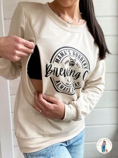 "Our Mama Boobery Brewing Co. Always on Tap 24/7 Two Locations Crewneck Sweatshirt is a must-have for breastfeeding mothers. It is designed for comfort and convenience by a breastfeeding mother of three littles with functionality in mind. Made from a soft cotton blend, this sweatshirt is soft, lightweight, and breathable. Unlike other Mama Boobery Brewing Co. design sweatshirts, this one has two convenient zippers on either side that make it easy to quickly zip open to reveal the opening and nurse your baby comfortably. Never worry about having to put on your nursing cover or covering your little one with a blanket. Our breastfeeding sweatshirt effortlessly combines the best of both worlds, comfort, and style. Make feeding time easy, wherever you are!  If you love the Mama Boobery design, Breastfeeding Outfits, Baby Items Must Have, Gifts For New Mom, Mommy Clothes, Mama Fashion, New Mom Gifts, Baby Life Hacks, Breastfeeding Clothes, Cute Maternity Outfits