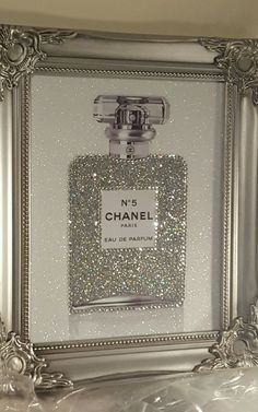 a chanel perfume bottle in a silver frame with glitter on the top and bottom