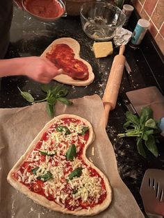 two pizzas are being prepared on the kitchen counter