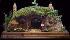 a fake hobbot house with flowers and plants on it