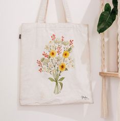 Say goodbye to plastic, and bag your goodies in this organic cotton tote bag. There's more than enough room for groceries, books, and anything in between. * 100% certified organic cotton 3/1 twill * Fabric weight: 8 oz/yd² (272 g/m²) * Dimensions: 16″ × 14 ½″ × 5″ (40.6 cm × 35.6 cm × 12.7 cm) * Weight limit: 30 lbs (13.6 kg) * 1″ (2.5 cm) wide dual straps, 24.5″ (62.2 cm) length * Open main compartment * Blank product components sourced from Vietnam This product is made especially for you as soon as you place an order, which is why it takes us a bit longer to deliver it to you. Making products on demand instead of in bulk helps reduce overproduction, so thank you for making thoughtful purchasing decisions! White Eco-friendly Flower-shaped Canvas Bag, Eco-friendly White Flower-shaped Canvas Bag, Eco-friendly White Canvas Bag For Mother's Day, Botanical Cotton Canvas Bag For Daily Use, Botanical Cotton Canvas Bag For Everyday Use, Eco-friendly Canvas Bag For Mother's Day, Botanical Cotton Canvas Gift Bag, Eco-friendly Cotton Canvas Bag For Mother's Day, Daily Use White Botanical Canvas Bag