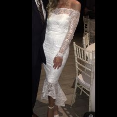 two people standing next to each other in front of white chairs at a formal event