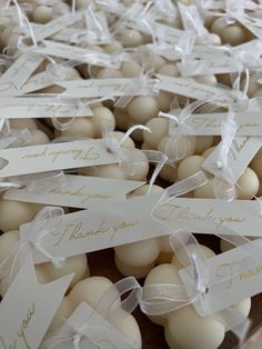 some white eggs are in a plastic container with tags on them that say thank you