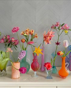 there are many different vases with flowers in them