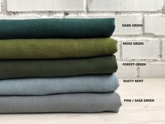 four different colors of fabric stacked on top of each other in front of a brick wall