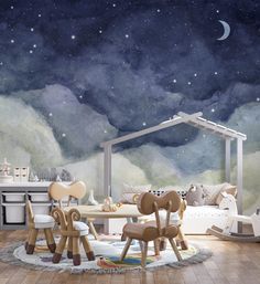 a child's room with stars and clouds painted on the wall, including a table and chairs