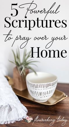 a white bowl sitting on top of a wooden table next to a potted plant