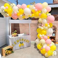 a bunch of balloons that are hanging from the ceiling in front of a table with lemons on it