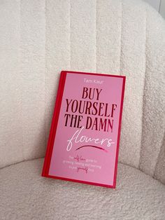 a pink book sitting on top of a white couch