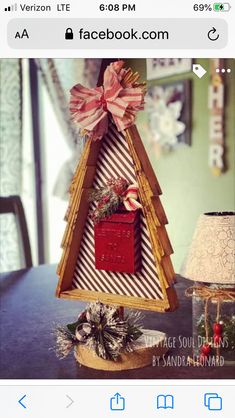 a christmas tree made out of cardboard with a red box on top and a pink bow