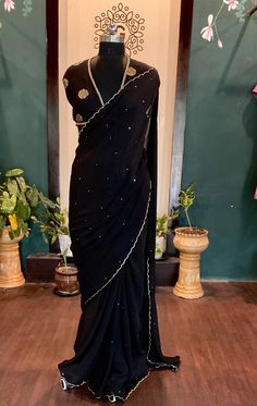 Beautiful black chinnon sari with  all over sequins and scalloped edges with an elegant dola silk brocade blouse saree fabric:chinnon length:5.5 meters blouse: 1m dola silk brocade black petticoat included Size: please choose a standard size from the drop down or you can choose custom measurements.  I'll send you a detailed measurements chart once you order. Party Pre-draped Chinon Saree With Mirror Work, Traditional Georgette Pre-draped Saree For Celebration, Pre-draped Georgette Saree For Celebration, Traditional Party Pre-draped Saree In Chanderi, Festive Black Pre-draped Saree With Cutdana, Black Pre-draped Saree With Pallu For Festive Occasions, Celebration Pre-draped Chinon Saree With Pallu, Black Pre-draped Saree With Cutdana, Black Georgette Pre-draped Saree With Resham Embroidery