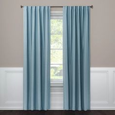 a blue curtain hanging in front of a window with wood floors and white trim on the walls