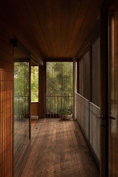 an empty porch with wooden flooring and blinds