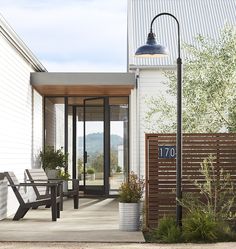 an outdoor patio with two benches and a lamp on the side of the building that reads 707