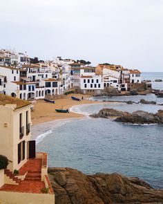 the beach is lined with white buildings and blue water in front of it, as well as steps leading down to the ocean