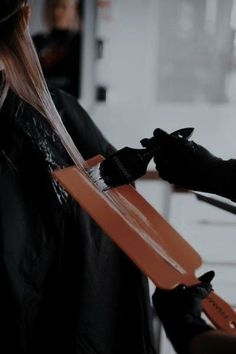 a woman getting her hair cut with scissors