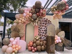 a bunch of balloons that are hanging on a wall in the shape of a house