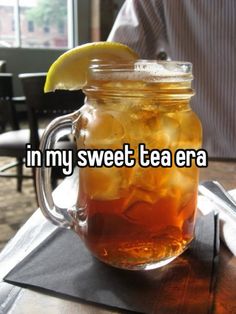 a mason jar filled with iced tea and lemon wedges