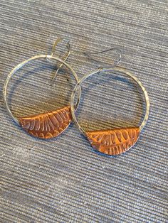 Circle and Fold!  These pounded sterling silver hoops have a fold over of copper that has been patterned using a rolling mill. They compliment each other perfectly.  Go Big or Go Home, have fun! Artisan Hammered Dangle Hoop Earrings, Adjustable Soldered Hoop Earrings For Gifts, Artisan Copper Hoop Earrings Nickel Free, Artisan Nickel Free Copper Hoop Earrings, Unique Nickel-free Copper Hoop Earrings, Rust Colored Hammered Copper Jewelry, Gift Hoop Earrings With Soldered Metal, Small Hoop Hammered Copper Earrings, Hammered Copper Round Hoop Earrings