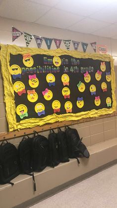 a bulletin board with smiley faces on it in a school hallway next to backpacks