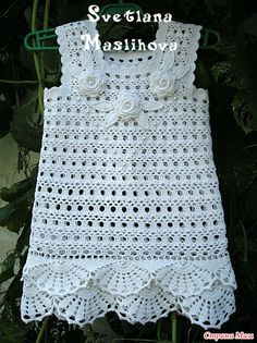 a white crocheted baby dress with flowers on it and the words svelana mashloro