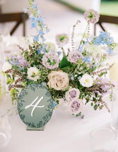 the table numbers are displayed with flowers and greenery on top of each other, along with an elegant centerpiece