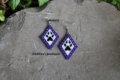 a pair of beaded earrings sitting on top of a rock