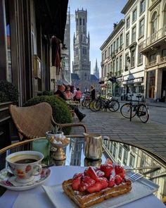 a table with some food on top of it next to a cup and saucer