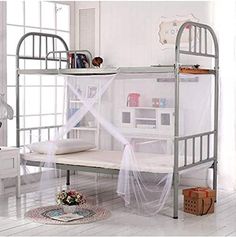 a metal bunk bed with mosquito netting on the top and bottom rails, in a white room