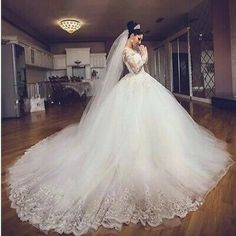 a woman in a wedding dress standing on a hard wood floor