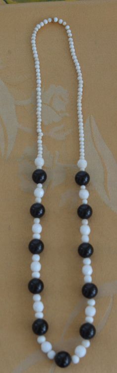 "Pretty vintage black and white glass beads accent this lovely necklace. It measures 24\" and does not have a clasp. It is in good vintage condition with minor wear on top of the black beads. They have dulled a bit, but will not be noticeable when worn. There is a small gap at the back of the necklace. Priced accordingly." Black Beaded Glass Necklaces, Adjustable Black Beaded Glass Necklaces, Glass Necklace With Black Round Beads, Vintage White Oval Bead Necklaces, Adjustable Black Vintage Beaded Necklace, Lovely Necklace, Glass Bead Necklace, Black Beads, White Glass