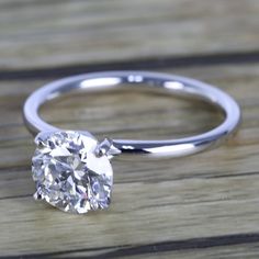 a close up of a diamond ring on a wooden table