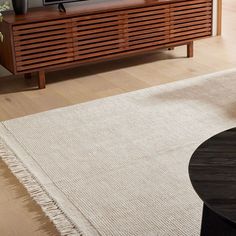 a flat screen tv sitting on top of a wooden entertainment center in a living room