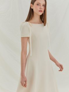 This product showcases a graceful midi dress with a flowing A-line skirt, designed to create an elegant and feminine silhouette. The dress features distinctive tie details at the shoulders, adding a charming touch to the simple yet sophisticated shape. With its fitted bodice and gently flared skirt, this piece offers both comfort and timeless style, making it suitable for various formal events. The shoulder ties serve as both a decorative and adjustable feature, allowing for a customized fit at the shoulders.The fitted bodice transitions smoothly into a flared skirt, accentuating the waist and providing a flattering drape.Its midi length is versatile and modest, suitable for a multitude of social settings and occasions.The dress is constructed with a discreet back zipper, making it ea Feminine Silhouette, Flared Skirt, Fitted Bodice, Flare Skirt, A Line Skirt, Timeless Style, Formal Event, A Line Skirts, Midi Length