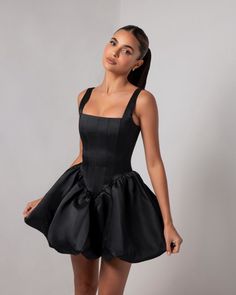 Introducing the Black Corset Sheen Mini Bubble Dress, a statement piece that exudes bold elegance and modern glamour. Crafted from our luxurious, runway-inspired sheen fabric, this dress catches the light beautifully, giving it a rich, polished look. The structured corset bodice cinches the waist to create an alluring hourglass silhouette, while offering impeccable support and comfort. The dramatic bubble skirt adds volume and a playful touch, making this mini dress a true standout. Perfect for Black Dress With Bow In The Back, Corset Dress Formal, Short Corset Dress, Black Bubble Dress, Mini Corset Dress, Structured Mini Dress, Heiress Beverly Hills, Black Bow Dress, Black Corset Dress