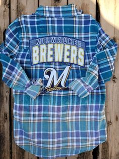 Measurements: 19.5" chest 28" length  24" sleeve length One-of-a-kind shirt with Milwaukee Brewers baseball pre-owned shirt graphics Woman's size S (slightly over-sized; see measurements) Tailgate in style Great for layering/jacket style Perfect for a cooler spring/summer/fall evening paired with shorts or leggings This custom shirt is perfect to wear to those game day tailgate parties. These handmade shirts make the perfect birthday gift or other special occasion gift for any Milwaukee Brewers baseball fan!  Up-cycling jean jackets, cozy flannels and plaid shirts and adding Green Bay Packers, Milwaukee Brewers, Wisconsin Badgers, sports teams or other pre-owned t-shirt graphics is one of my passions and I'm thrilled to offer you a chance to own a one-of-a-kind custom shirt! All materials Casual Baseball Fan Gear Shirt, Cotton Sports Fan Shirt For College, Vintage Screen Print Fan Gear T-shirt, Winter Fan Gear Graphic T-shirt, Vintage Fan Gear T-shirt With Graphic Print, Cotton Baseball Fan Merchandise Shirt, Vintage Flannel Top With Graphic Print, Sports Fan Baseball Jersey With Graphic Print, Crew Neck, Bleached Flannel Shirt