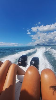 the back end of a boat with two people on it and one person laying down