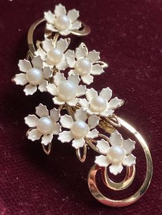 Pretty white enamelled flower brooch set with central faux pearls on gold metal Elegant Enamel Flower Brooches, Elegant White Enamel Pin, White Flower Enamel Pin For Wedding, Vintage White Pins For Anniversary, Elegant Formal Flower Enamel Pin, Elegant Formal Flower Shaped Enamel Pin, White Enamel Brooch Jewelry, Elegant White Enamel Pin For Gift, Elegant Flower Shaped Enamel Pin For Formal Occasions