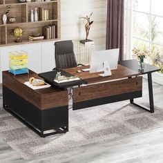 an office desk with a laptop on it in front of a book shelf and window