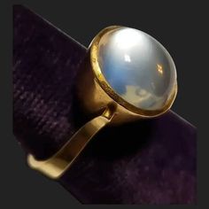 I am delighted to offer for your consideration this beautiful vintage 18K gold moonstone ring. Interior is marked 750 and has been tested to assure the golds purity. An elegant design that will surely be noticed and admired! The moonstone is clear and in the right angles it has that fantastic glow! Moonstone measures 11.19mm by 10.23mm. Held in a secure bezel setting that measures 12.68mm by 11.69mm. The setting is just slightly over 2/8 of an inch tall. Including the stone it's 3/8 of an inch tall. Sides of shank is 2.20mm and it is 3.92mm at the base of ring. Size is 6 1/4 with a total weight of 7 grams. In good vintage condition. You'll be delighted wearing this stunning ring! Please make sure to ask all necessary questions prior to purchase. Thank you! Antique Oval Moonstone Ring Collectible, Heirloom Yellow Gold Moonstone Cabochon Ring, Hallmarked Yellow Gold Moonstone Ring, Yellow Gold Moonstone Ring With Polished Oval Cabochon, Yellow Gold Moonstone Ring With Oval Cabochon, Luxury Polished Moonstone Ring In 14k Gold, Luxury 14k Gold Moonstone Ring With Polished Finish, Classic Yellow Gold Moonstone Ring With Polished Finish, Elegant Cabochon Moonstone Ring For Anniversary