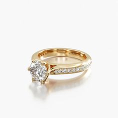 a yellow gold engagement ring with a single diamond on the side and two rows of white diamonds