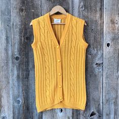 Vintage 1960s era 100% wool sweater vest by Tami. No size on tag, would likely fit a size Small best. Mustard yellow color, in cable and rib knit pattern. Plastic, possible bakelite buttons. Long line cut.  A tad bit of fading in the armpits, otherwise great vintage condition!   Measurements:  Pit to pit: 17"  Length: 27" in the back Fitted Cable Knit Sweater Vest For Fall, Fitted Cable Knit Vest For Fall, Vintage Sweater Vest For Fall Workwear, Fitted Cable Knit Vest, Classic Cable Knit Sweater Vest For Fall, Vintage Wool Sweater Vest For Winter, Fitted Wool Sweater Vest In Vintage Style, Vintage Knit Sweater Vest For Fall, Yellow Fitted Vintage Cardigan