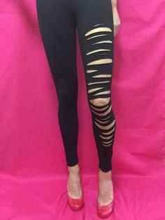 Sleek and chic on the left, ripped and raw on the right, these distressed black leggings with ankle zippers boast the perfect asymmetrical contrast. These one-of-a-kind slashed leggings are staple streetwear at its finest. (Size Small.) Ripped Punk Bottoms For Night Out, Edgy Stretch Leggings, Edgy Fall Streetwear Leggings, Black Stretch Bottoms With Holes, Edgy Bottoms With Holes For Fall, Stretch Ripped Grunge Bottoms, Edgy Stretch Bottoms With Holes, Stretch Ripped Bottoms In Grunge Style, Grunge Style Stretch Ripped Bottoms