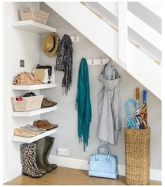 an organized closet under the stairs with shoes, scarves and purses