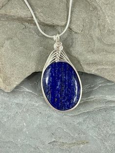 This natural Lapis Lazuli necklace is gorgeous! Lapis Lazuli stone has been valued for centuries and Prized for its vibrant royal blue color.  I chose to enhance this beautiful smooth stone with a woven silver wire design to let the natural beauty of the gemstone shine. Pair this flattering necklace with your favorite sweater or blouse, dressed up or down, the possibilities are endless!This necklace is handmade by me with a genuine smooth Lapis Lazuli stone. The necklace you will receive will be Handmade Oval Lapis Lazuli Necklace, Blue Oval Pendant Necklace With Spiritual Style, Blue Oval Pendant Necklace With Natural Stones, Sapphire Oval Necklace With Natural Stones, Oval Sapphire Necklace With Natural Stones, Blue Oval Necklace With Natural Stones, Blue Stones Jewelry, Wire Design, Lapis Lazuli Jewelry